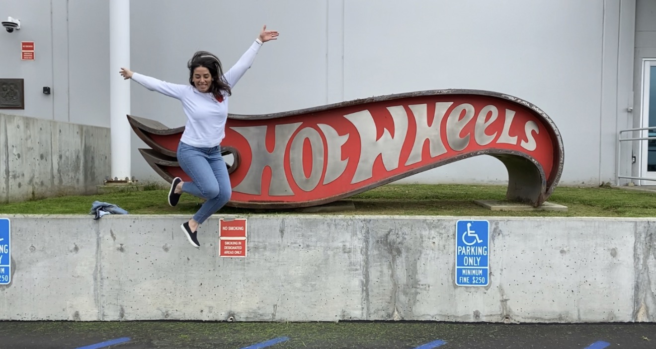 Florence Boza jumping in front of the Hot Wheels sign at Mattel